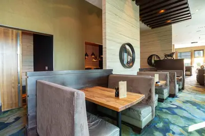 a restaurant with a wooden table and chairs at Sandman Signature Edmonton South Hotel in Edmonton
