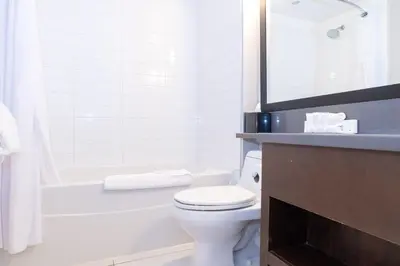 a bathroom with a toilet and a tub and a sink at Sandman Signature Edmonton South Hotel in Edmonton