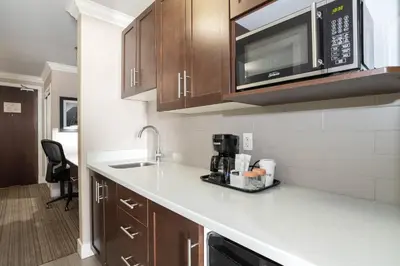 a kitchen with a sink and a microwave at Sandman Hotel & Suites Calgary South in Calgary