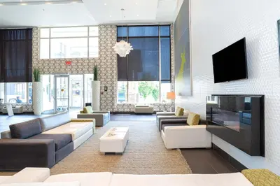 a living room with couches and a flat screen tv at Sandman Hotel & Suites Calgary South in Calgary
