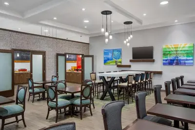 a dining room with tables and chairs and a tv at Hampton Inn by Hilton Kamloops in Kamloops