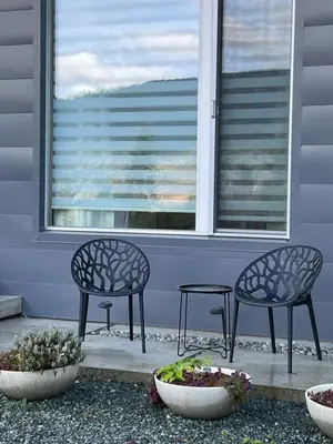 two chairs and a table in front of a window at The Cube Cow Bay Suite in Cowichan Bay