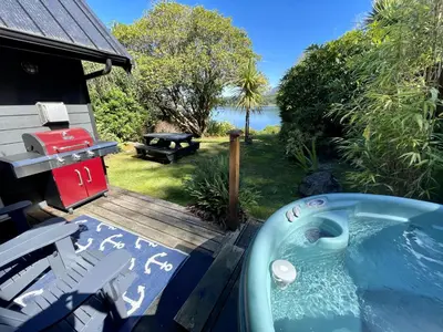a backyard with a hot tub and a grill at Private Oceanfront Cabin And Hot Tub! - Gww in Ucluelet