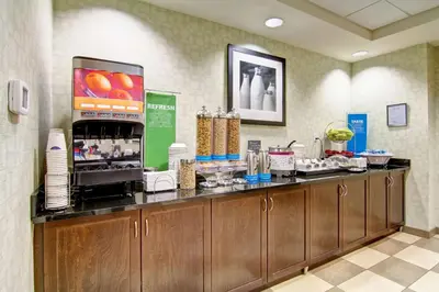 a restaurant with a counter with aasteryasteryasteryasteryasteryasteryasteryasteryastery at Hampton Inn & Suites Red Deer in Red Deer