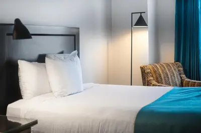 a bedroom with a white bed and a chair at Ramada by Wyndham Surrey/Langley in Surrey
