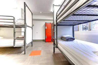 a dorm room with two bunk beds and a red door at HI Edmonton - Hostel in Edmonton