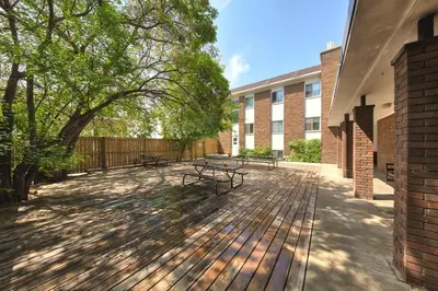 a patio with benches and trees in front of a building at HI Edmonton - Hostel in Edmonton