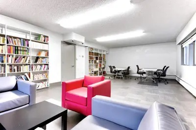 a living room with a couch and chairs and a table at HI Edmonton - Hostel in Edmonton