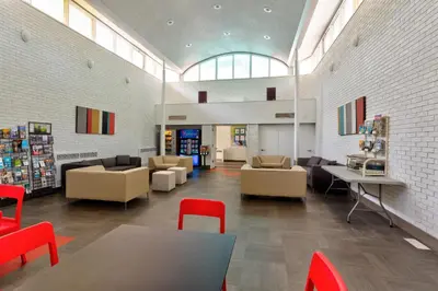 a library with tables and chairs and a book store at HI Edmonton - Hostel in Edmonton
