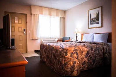 a hotel room with a large bed and a window at Langley Hwy Hotel in Langley