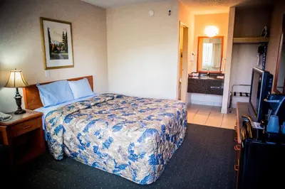 a hotel room with a bed and a television at Langley Hwy Hotel in Langley
