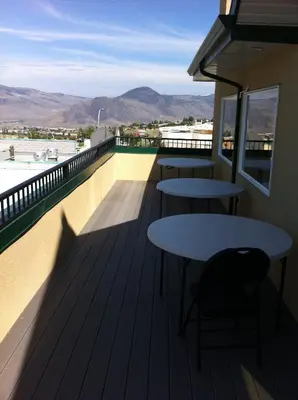 two tables on a balcony with mountains in the background at Days Inn by Wyndham Kamloops BC in Kamloops