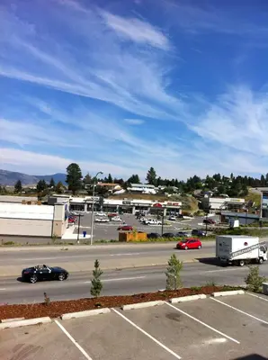 a view of a parking lot with cars and buildings at Days Inn by Wyndham Kamloops BC in Kamloops