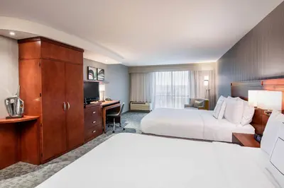 a hotel room with a bed and a desk at Courtyard by Marriott Edmonton West in Edmonton