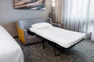 a hospital room with a bed and a chair at Courtyard by Marriott Edmonton West in Edmonton