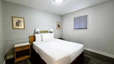 a bedroom with a large white bed and a window at Okanagan Seasons Resort in Kelowna