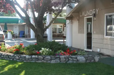 a flower bed in front of a building with a tree at Okanagan Seasons Resort in Kelowna