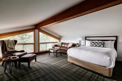 a bedroom with a bed and a couch and a chair at Pyramid Lake Lodge in Jasper