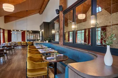 a restaurant with tables and chairs and windows at Pyramid Lake Lodge in Jasper