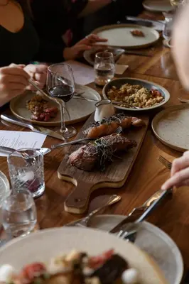 a wooden table with plates of food and glasses of wine at Pyramid Lake Lodge in Jasper