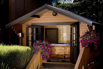 a small sauna with purple flowers on the porch at Marmot Lodge Jasper in Jasper