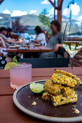 a plate of corn on the cob and a glass of wine at The Crimson Jasper in Jasper