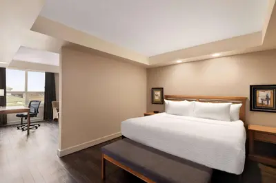 a hotel room with a bed and a desk at Royal Hotel Edmonton Airport Trademark Collection By Wyndham in Leduc