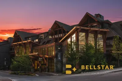 a large building with a sunset in the background at Bellstar Suites at Solara Resort in Canmore