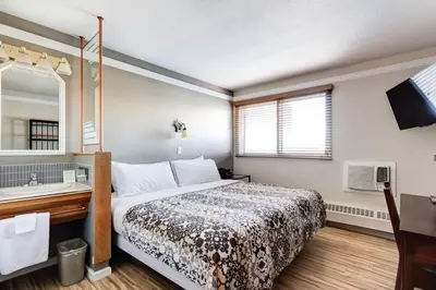 a bedroom with a bed and a sink and a mirror at Astoria Hotel in Jasper