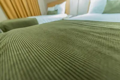 a close up of a bed in a hotel room at Howard Johnson by Wyndham Downtown Kamloops in Kamloops