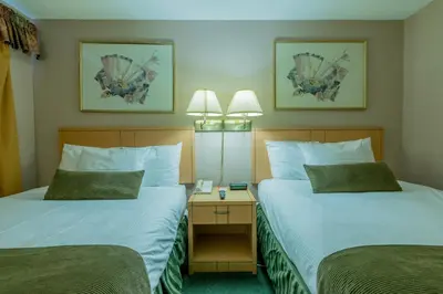 a hotel room with two beds and two lamps at Howard Johnson by Wyndham Downtown Kamloops in Kamloops