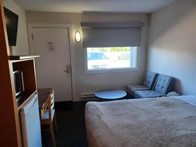 a hotel room with a bed and a couch and a window at Grandview Motel in Kamloops