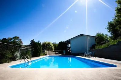 a large swimming pool with blue water in a yard at Grandview Motel in Kamloops