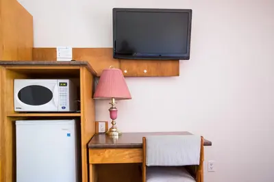 a room with a microwave and a table with a lamp at Grandview Motel in Kamloops