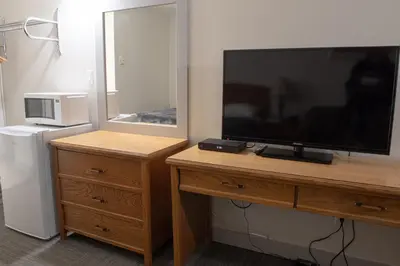 a television on a wooden dresser with a dresser with a dresserngth at Grandview Motel in Kamloops