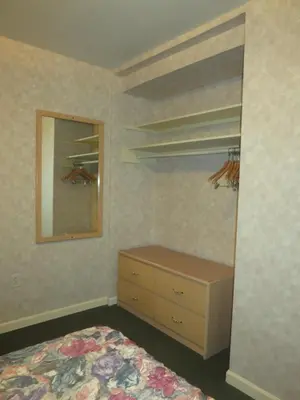 a bedroom with a bed and a dresser and a mirror at Tropicana Suite Hotel in Vancouver