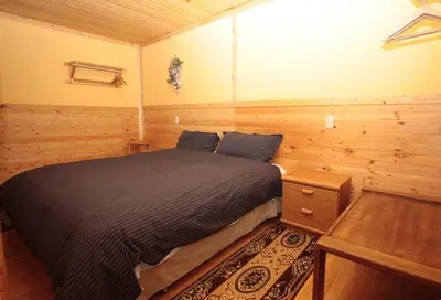a bedroom with a bed in a wooden room at Glenogle Mountain Lodge and Spa in Golden