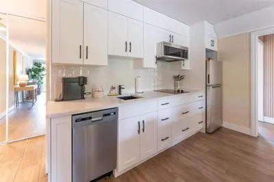 a kitchen with white cabinets and stainless steel appliances at Prestige Beach House, WorldHotels Crafted in Kelowna