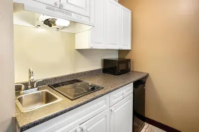 a kitchen with a sink and a microwave at Days Inn by Wyndham Nanaimo in Nanaimo