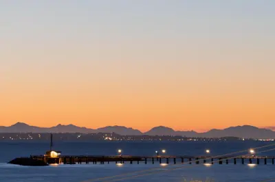 a pier in the water at sunset at Ocean Promenade Hotel in White Rock