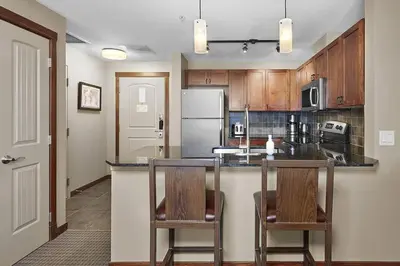 a kitchen with two chairs and a counter top at Mountain View Escape with open hot tub, Views!! in Canmore