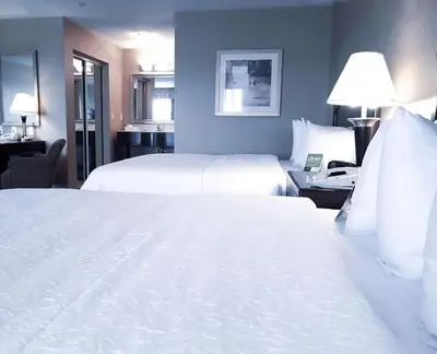 a hotel room with two beds and a desk at Hampton Inn & Suites by Hilton Edmonton International Airport in Leduc
