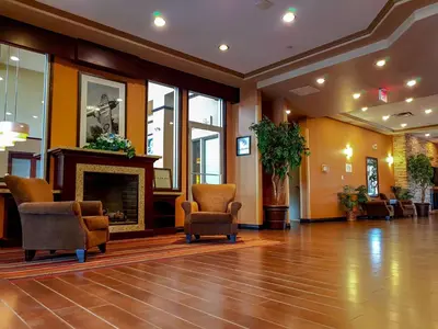 a lobby with chairs and a fireplace at Hampton Inn & Suites by Hilton Edmonton International Airport in Leduc
