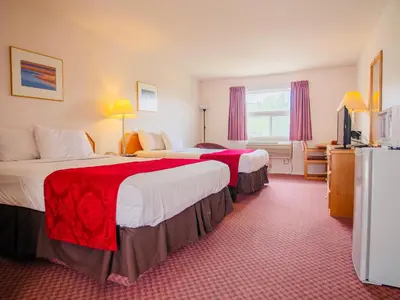 a hotel room with two beds and a television at Country View Motor Inn in Kamloops