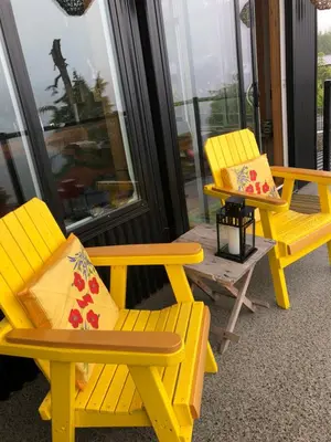 two yellow chairs and a table and a bench at Bjørn Holm in Port Renfrew