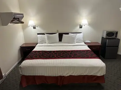 a hotel room with a bed and a tv at Kings Motor Inn in Kamloops