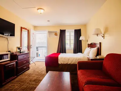 a hotel room with a bed and a couch at Kings Motor Inn in Kamloops