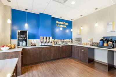a coffee shop with a blue wall at Days Inn by Wyndham Airdrie in Airdrie