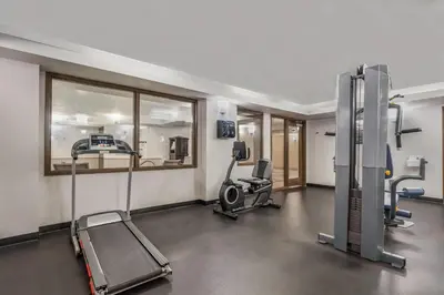 a gym with treadmills and machines in a room at Days Inn by Wyndham Airdrie in Airdrie
