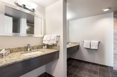 a bathroom with a sink and a mirror at Days Inn by Wyndham Airdrie in Airdrie